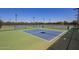 Outdoor pickleball courts area with green and blue courts, black chain-link fence and street lights at 24746 N 171St Ln, Surprise, AZ 85387