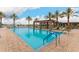Community pool featuring lounge chairs, sun umbrellas, and palm trees in a serene outdoor setting at 24746 N 171St Ln, Surprise, AZ 85387