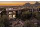 Beautiful Scottsdale home boasts desert landscape, luxurious exterior, and a picturesque mountain view at sunset at 25555 N Windy Walk Dr # 34, Scottsdale, AZ 85255