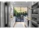 Galley kitchen with modern appliances and light wood floors overlooking an outdoor dining space at 25555 N Windy Walk Dr # 34, Scottsdale, AZ 85255