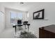 Bright home office with glass top desk, zebra rug, and plantation shutters at 25555 N Windy Walk Dr # 34, Scottsdale, AZ 85255