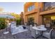 Beautiful brick patio with grill, white lounge furniture, outdoor dining table, and scenic backyard at 25555 N Windy Walk Dr # 34, Scottsdale, AZ 85255