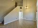 Bright living room featuring high ceilings, neutral walls, tiled floor, and a staircase to the second level at 2634 S 63Rd Dr, Phoenix, AZ 85043