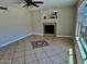Comfortable living room featuring a tile fireplace, ceiling fan, tiled floor, and large windows for natural light at 2634 S 63Rd Dr, Phoenix, AZ 85043