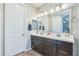 Bright bathroom featuring double sinks, a large mirror, and glass block partition at 277 E Kaibab Dr, Chandler, AZ 85249