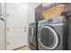 A laundry room with gray washer and dryer, cabinets, and white door at 277 E Kaibab Dr, Chandler, AZ 85249