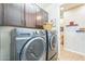Laundry room with modern washer and dryer, built-in cabinets, and efficient organization features at 277 E Kaibab Dr, Chandler, AZ 85249