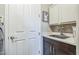 Functional laundry room features a deep sink, white cabinets, and a convenient layout for laundry tasks at 277 E Kaibab Dr, Chandler, AZ 85249