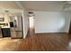 Open living room with stainless refrigerator, hardwood flooring, and an entry to bedroom hallway at 2838 E Contessa St, Mesa, AZ 85213