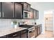 Close-up of the stylish dark cabinetry, granite countertops, and stainless steel appliances in this updated kitchen at 37252 N Big Bend Rd, San Tan Valley, AZ 85140