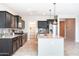 Open kitchen layout with modern dark cabinets, granite countertops, stainless steel appliances and a walk-in pantry at 37252 N Big Bend Rd, San Tan Valley, AZ 85140
