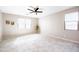 Bright living room with tile floors, large windows, and a ceiling fan creating a comfortable space at 37252 N Big Bend Rd, San Tan Valley, AZ 85140