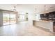 Open-concept living room with tile floors, large sliding glass doors, and modern kitchen with granite countertops at 37252 N Big Bend Rd, San Tan Valley, AZ 85140