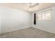 A simple carpeted bedroom has a window with shutters and a ceiling fan at 3825 W Royal Palm Rd, Phoenix, AZ 85051