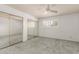 A carpeted bedroom with shuttered window, ceiling fan, and mirrored closet at 3825 W Royal Palm Rd, Phoenix, AZ 85051