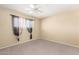 This carpeted bedroom features a window and a ceiling fan at 3825 W Royal Palm Rd, Phoenix, AZ 85051