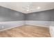 Well-lit flex room with new laminate flooring, white ceiling fan, and gray painted walls at 3825 W Royal Palm Rd, Phoenix, AZ 85051