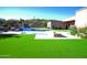 Expansive backyard featuring a luxurious pool, verdant artificial turf, and desert landscaping at 4008 La Ultima Piedra --, Carefree, AZ 85377