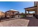 Spacious backyard featuring a gazebo, outdoor seating, and play area with green turf at 40213 W James Ln, Maricopa, AZ 85138