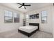 Well-lit bedroom with neutral decor, plush carpet, and multiple windows for natural light at 40213 W James Ln, Maricopa, AZ 85138