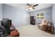 Bedroom with a large window, neutral walls, ceiling fan and a comfortable chair at 4353 W Villa Rita Dr, Glendale, AZ 85308