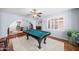 Elegant game room with pool table, white rug, hardwood floors, and seamless transition to dining area at 4353 W Villa Rita Dr, Glendale, AZ 85308