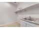 Laundry room featuring a stainless steel sink, white cabinets, and ample counter space at 4360 N 186Th Ln, Goodyear, AZ 85395