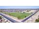 Aerial view of the school, sports field, and desert landscaping in a residential community with mountain views at 4404 W Olney Ave, Laveen, AZ 85339