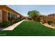 Expansive backyard with a lush lawn, outdoor kitchen, and privacy wall, creating a serene retreat at 4404 W Olney Ave, Laveen, AZ 85339