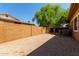 Enclosed backyard featuring low-maintenance gravel, a privacy fence, and shade trees, creating a blank canvas at 4404 W Olney Ave, Laveen, AZ 85339