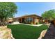 Beautifully landscaped backyard with a lush lawn, mature trees, and an outdoor grilling area at 4404 W Olney Ave, Laveen, AZ 85339
