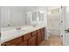 Bright bathroom featuring double sinks, wood cabinets, and tile floors at 4404 W Olney Ave, Laveen, AZ 85339