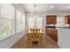 Bright dining area with a wooden table, seating for eight, and natural light from the large windows at 4404 W Olney Ave, Laveen, AZ 85339