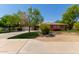 Inviting single-story home with lush lawn, mature trees, colorful flowers, and a two-car garage at 4404 W Olney Ave, Laveen, AZ 85339
