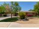 Beautiful single-story home with a well-manicured lawn, colorful flowering bushes, and a two car garage at 4404 W Olney Ave, Laveen, AZ 85339