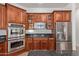 Kitchen with wood cabinets, stainless steel appliances, dark countertops, and a built-in microwave and oven at 4404 W Olney Ave, Laveen, AZ 85339