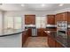 Well-lit kitchen features dark countertops, wood cabinetry, tile flooring, and stainless steel appliances at 4404 W Olney Ave, Laveen, AZ 85339