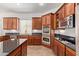 Modern kitchen showcasing wood cabinets, dark countertops, tile flooring, and stainless steel appliances at 4404 W Olney Ave, Laveen, AZ 85339