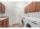 Laundry room with a sink, wood cabinets, and front-loading washer and dryer at 4404 W Olney Ave, Laveen, AZ 85339