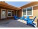 A cozy outdoor patio featuring comfortable blue Adirondack chairs, perfect for relaxing and enjoying the fresh air at 4404 W Olney Ave, Laveen, AZ 85339