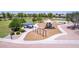 Aerial view of the community playground with swings, a slide, and picnic tables surrounded by grassy fields at 4404 W Olney Ave, Laveen, AZ 85339