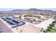 An aerial view shows the school with solar panel carports, a playground, and sports courts surrounded by desert landscaping at 4404 W Olney Ave, Laveen, AZ 85339