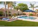 Resort-style backyard with a pool, waterfalls, outdoor seating, artificial turf, and mature landscaping at 4422 E Spur Dr, Cave Creek, AZ 85331