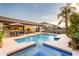 Stunning backyard featuring a pool, spa, outdoor kitchen, dining area, mature trees, and a well-manicured lawn at 4422 E Spur Dr, Cave Creek, AZ 85331