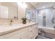 Modern bathroom with a double vanity with decorative plant, tile shower with glass door, and neutral color palette at 4422 E Spur Dr, Cave Creek, AZ 85331