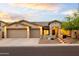 Charming single-story home featuring desert landscaping, a three-car garage, and beautiful sunset lighting at 4422 E Spur Dr, Cave Creek, AZ 85331