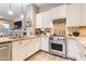 Modern kitchen featuring white cabinets, stainless steel appliances, and stylish countertops with a decorative backsplash at 4422 E Spur Dr, Cave Creek, AZ 85331