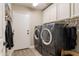 A laundry room with gray front load washer and dryer, cabinets, and a door to the exterior at 4422 E Spur Dr, Cave Creek, AZ 85331