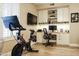 Home office area with a workout bike, custom built-in cabinets and shelving, and a wood desk at 4422 E Spur Dr, Cave Creek, AZ 85331