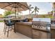 Outdoor kitchen featuring a built-in grill, bar seating, and stylish countertops perfect for entertaining at 4422 E Spur Dr, Cave Creek, AZ 85331